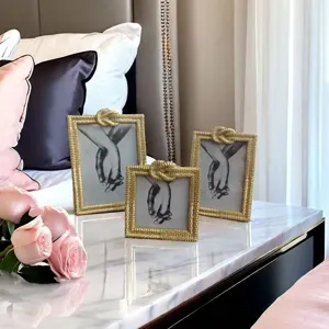 Gold braided photo frames detail showcasing luxury home decor and aesthetic hand art display.