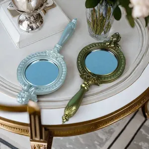 Vintage europäische Handspiegel mit verzierten Harzschnitzereien in Blau und Grün.