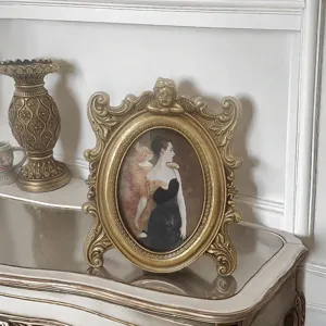 Vintage ornate gold resin picture frame with cherub detail on a mirrored surface