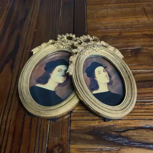 Close-up of ornate gold vintage resin photo frames featuring classical art portraits