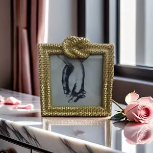 Exquisite gold decorative photo frame detail showing luxurious rope knot texture and elegant aesthetic.