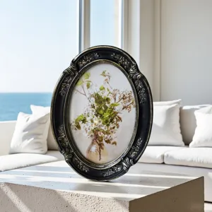 Close-up of vintage oval black and gold frame with ornate floral carvings
