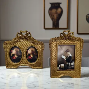 French vintage gold resin photo frame, ornate bow and floral desktop decor detail view.