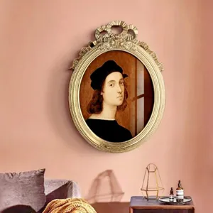Ornate gold resin photo frame in European vintage style shown hanging on a pink wall
