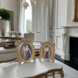 Detailed view of two vintage gold resin photo frames with baroque carvings on a table