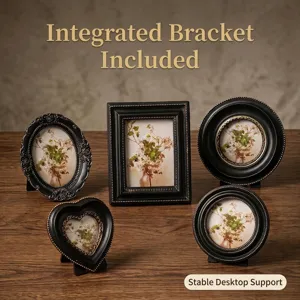 Set of vintage black and gold picture frames in heart, oval, and round shapes on wood desk