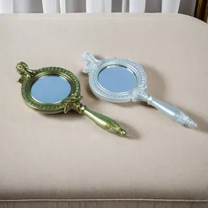 Vintage-Handspiegel mit geschnitztem Griff und Relief in Gold- und Silberoptik