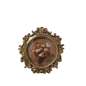 Vintage gold ornate photo frame with classic floral painting for home decor and tabletop.