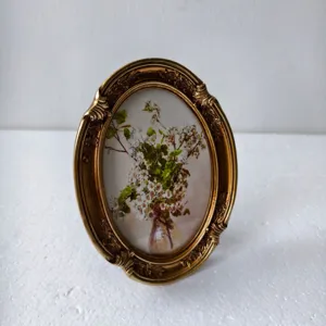 Elegant vintage gold oval photo frame with ornate carvings and distressed antique finish