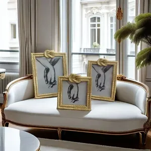 Luxury gold picture frames set with black and white hand art prints for modern living room decor.