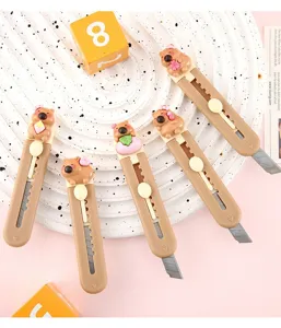 Gros plan de cinq mini-cutters mignons en forme de cochon d'Inde sur un plateau blanc