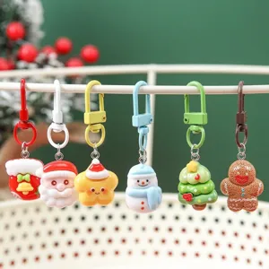 Colorful set of six cartoon Christmas-themed keychain pendants hanging on a white rack