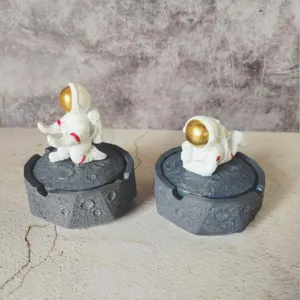 Resin astronaut figurine detail shot showing intricate moon crater texture base and gold visor.
