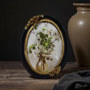Cadre photo ovale vintage avec finition or et noir ornée et impression d'art floral.