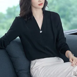 Primer plano de un elegante broche de cisne de cristal con circonitas en una blusa negra