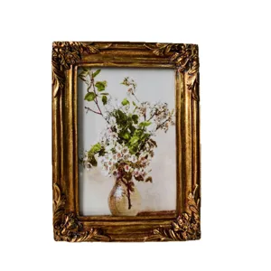 Cornice portafoto vintage in resina con arte floreale, decorazione murale dorata antica.