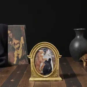 Vintage European style hand-carved golden resin photo frame displayed on a wooden desk