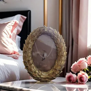 Vintage resin photo frame with retro gold feather design for elegant tabletop home decor.