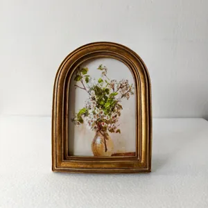European retro arched resin photo frame detail, vintage golden decorative picture frame display.