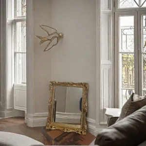 Detailansicht von goldenem Harz-Wandschmuck und verziertem Bilderrahmen im Vintage-Stil