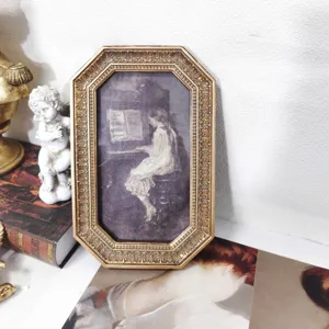 Cornice ottagonale dorata vintage con dettagli in rilievo e pittura a olio ragazza piano