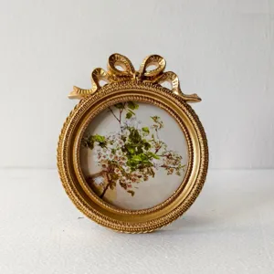 European retro gold resin round photo frame with bow detail and floral art print for home decor