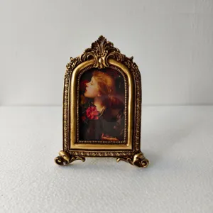 European vintage resin photo frame with ornate carved design and classical art print insert.