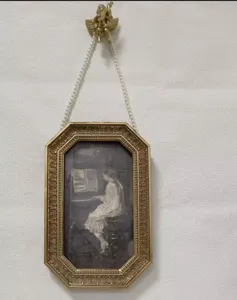 Cornice decorativa dorata in rilievo con catena di perle e arte classica di ragazza