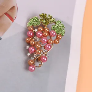 Close-up view of a fashionable grape brooch with pink pearls and green rhinestones