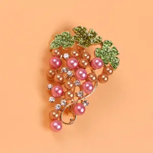 Detailed view of elegant grape brooch with pink pearls and green crystal leaf accents