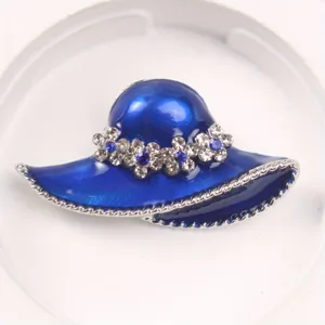 Detailed macro view of a royal blue hat brooch adorned with sparkling rhinestones.
