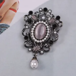 Primer plano detallado de broche barroco vintage con gema rosa y detalle de perla