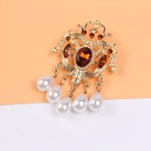 Primer plano detallado de broche barroco vintage con cristales ámbar y perlas gota