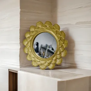 Vintage gold round resin frame with intricate scalloped carvings on a marble surface
