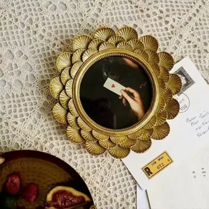 Close-up of vintage golden round photo frame with intricate scalloped shell carvings