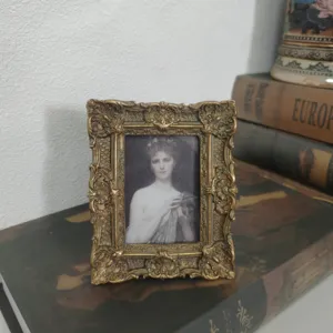 Detailed view of ornate vintage gold resin picture frame with classic carved patterns.
