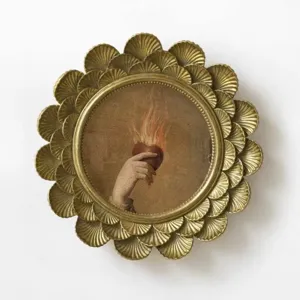 Detail of vintage golden carved resin round frame with classical flaming heart art