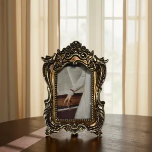Primer plano detallado de un marco de fotos de resina vintage con borde dorado tallado en mesa.