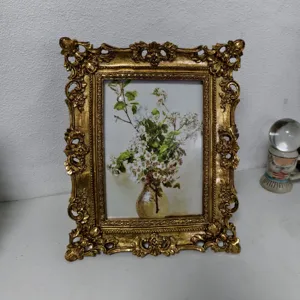 Vista dettagliata di una cornice dorata vintage decorata con stampa artistica floreale classica