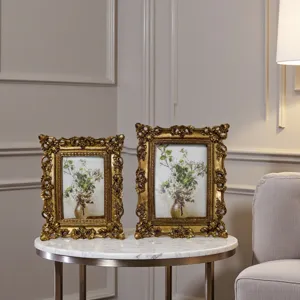 Set di due cornici vintage dorate su un tavolo di marmo in un elegante arredamento