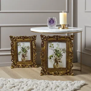 Dettaglio di cornici dorate vintage intagliate con opere d'arte floreali in stanza.