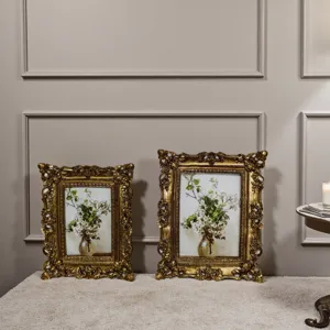 Eleganti cornici vintage dorate intagliate con arte floreale in ambiente domestico.