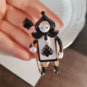 Handheld close-up of a vintage black spade soldier brooch made of alloy and enamel