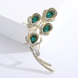 Detail view of a vintage emerald green calla lily brooch with sparkling rhinestones