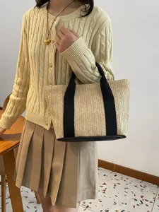 Elegante bolso de paja tejido con detalles negros ideal para las vacaciones de verano