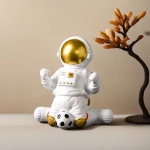 Detail view of a white astronaut figurine sitting and playing with a small soccer ball.