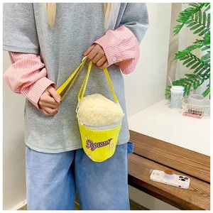 Détail d'un enfant portant un sac en peluche jaune en forme de popcorn avec polaire douce