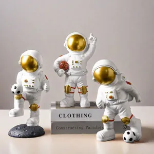 Macro view of three creative white and gold astronaut figurines for desk decoration