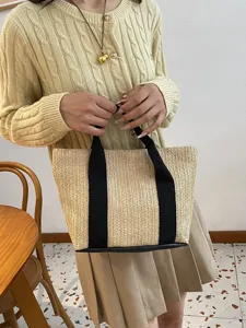 Vista detallada de un bolso de paja tejido a mano ideal para las vacaciones de playa
