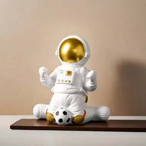 Creative astronaut figurine sitting with a soccer ball for modern home office decor